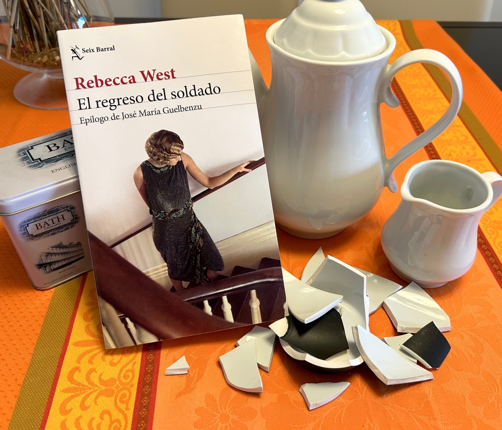 Un ejemplar de la novela "El regreso del soldado", de Rebecca West, junto a una tetera, una jarrita de leche y una taza rota.